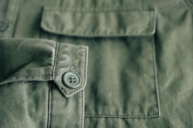 Tło składanego rękawa zielonej kurtki na kieszeni i dziurce na guzik z linią szwu