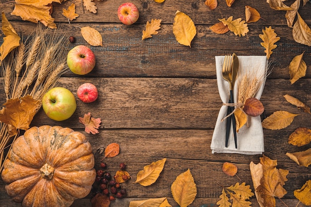 Tło święta Dziękczynienia Z Jesiennymi Liśćmi Dyniowych Jabłek I Sztućców Na Drewnianym Tle