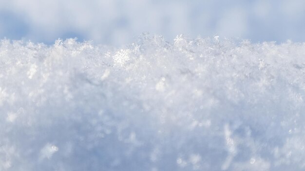 Tło świeżego śniegu. Naturalne zimowe tło. Tekstura śniegu w odcieniu niebieskim