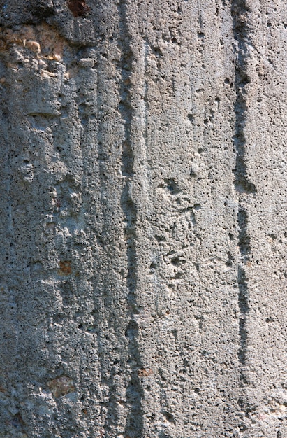 Zdjęcie tło szarej starej betonowej ściany z wiórami i nierównościami