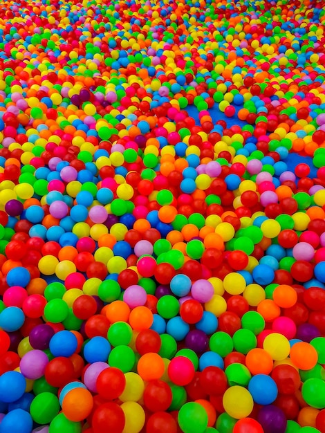 Tło wielu plastikowych kolorowych kulek w basenie z piłeczkami w pokoju gier dla dzieci