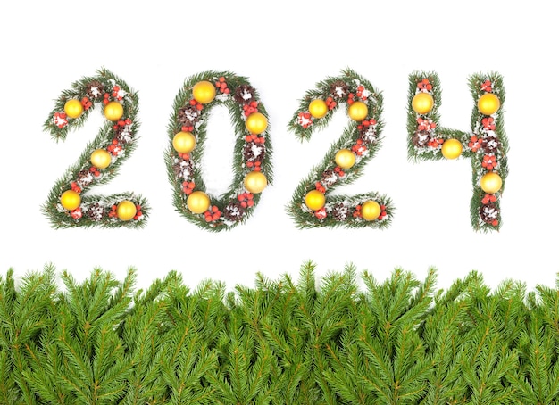 Zdjęcie tło wigilię bożego narodzenia i numer 2024 wykonane przez gałęzie choinki izolowane na białym tle