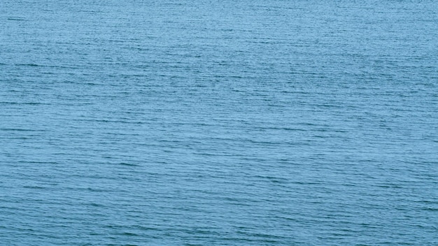 Zdjęcie tło wody morskiej ruch małych fal ruch niebieskiej powierzchni wody morskiej nieruchomy