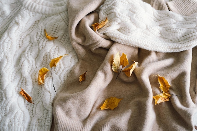 Tło z ciepłymi sweterami Gromada dzierżonych ubrań z jesiennymi liśćmi Ciepły tło przestrzeń dla tekstów Autumn winter concept Copy Space