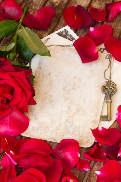 Tło z czerwonymi płatkami róż i złoty klucz