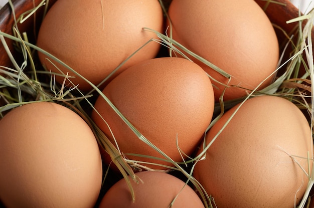 Tło żywności brązowych organicznych jaj w glinianej misce