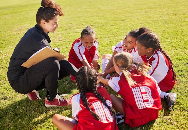 Tłocz sport lub trener z rękami dzieci do treningu strategii piłki nożnej lub celów zespołowych w Kanadzie Koło budowania zespołu lub kobieta i grupa dziewcząt na boisku piłkarskim na mecz lub trening wsparcia gry