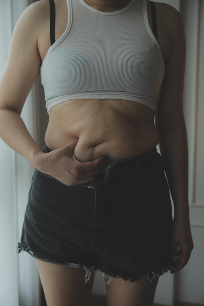 Zdjęcie tłusta kobieta mierząca tłusta kobieta tłusta brzuch gruby brzuch sport rekreacja opieka zdrowotna tracić tłuszcz brzucha nie ćwiczyć koncepcja