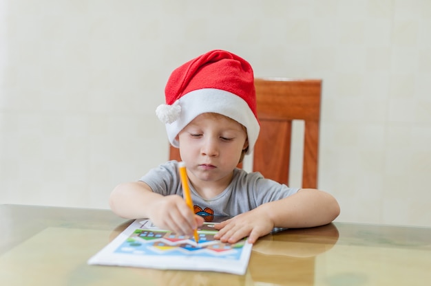 Toddler Boy rysuje ścieżkę pisaka w labiryncie. Koncepcja wczesnego rozwoju