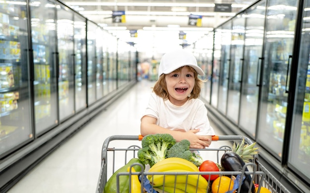 Toddler chłopiec dziecko z torbą na zakupy w supermarkecie