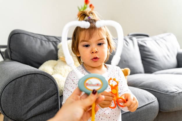 Toddler dziewczynka bawi się z zestawem lekarza i lalek