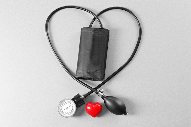 Zdjęcie tonometr z czerwonym sercem na szarym stole