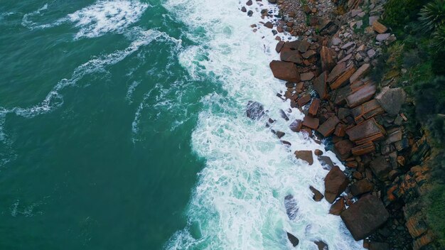 Top burzliwy ocean łamiący się na przybrzeżnych kamieniach z pianką powietrzne morze rozbijające się wybrzeże