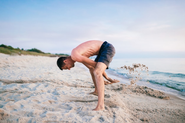 Topless mężczyzna na plaży kopanie dołu