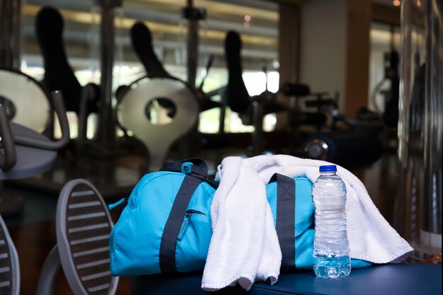 Zdjęcie torba z rzeczami osobistymi, ręcznikiem i butelką wody na siłowni
