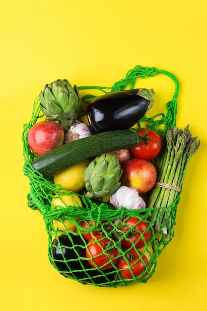 Zdjęcie torba z siatki włókienniczej z owocami i warzywami na żółtym tle, zero odpadów, przyjazna dla środowiska