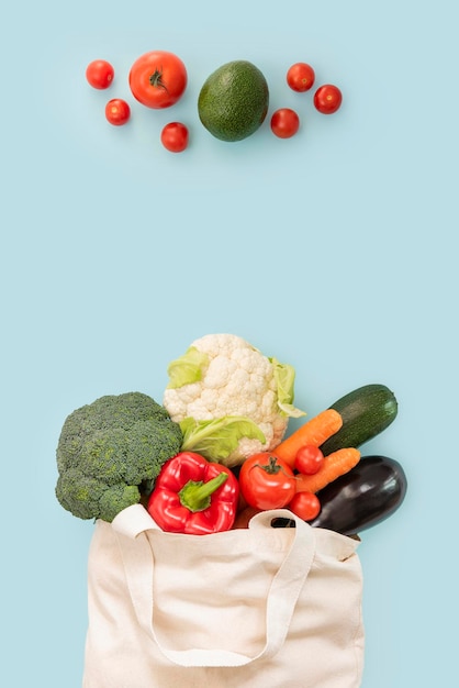 Zdjęcie torba ze świeżymi warzywami na niebieskim tle z miejscem na tekst