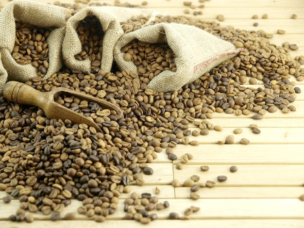 Torba ziaren kawy leży na drewnianej podłodze z torbą ziaren kawy.