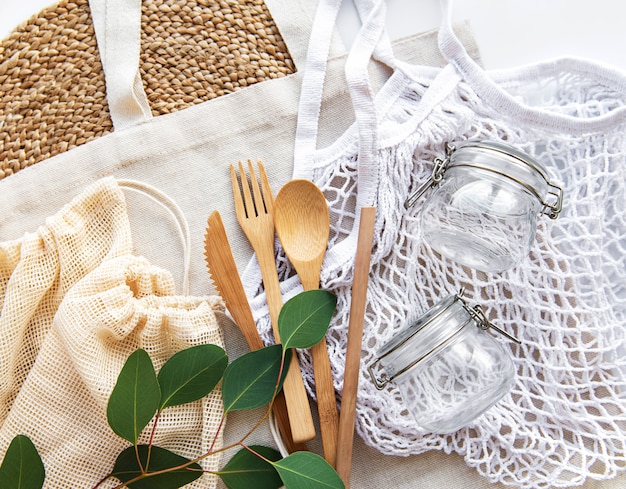 Torby bawełniane, torba z siatki ze szklanymi słoikami wielokrotnego użytku i bambusowymi sztućcami. Koncepcja zero waste. Przyjazny dla środowiska. Leżał na płasko