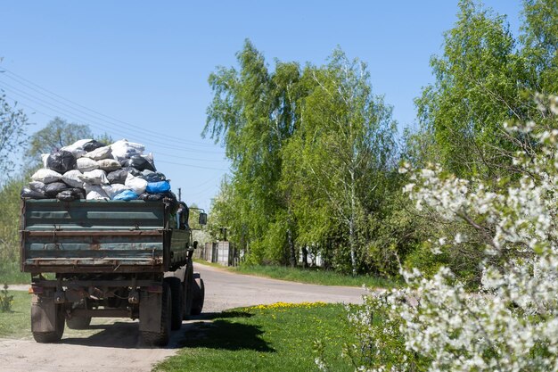 Torby z śmieciami w przyczepie sprzątają teren