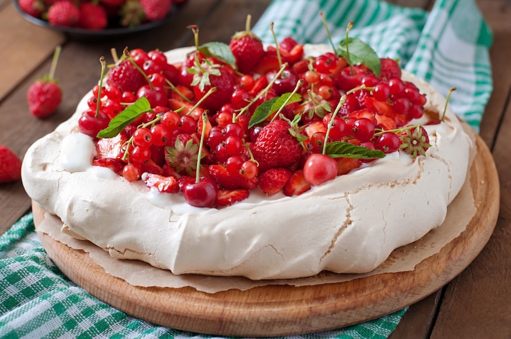 Zdjęcie tort bezowy „pavlova” ze śmietaną i jagodami