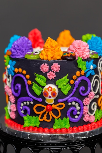Tort dla smakoszy Dia de los Muertos ozdobiony kolorowym kremowym lukrem i gumowatymi nakładkami na babeczki.