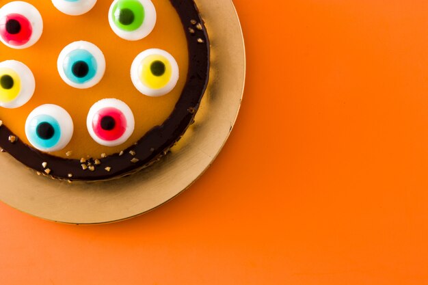 Tort Halloween z ozdobą oczu cukierków na pomarańczowo. Widok z góry.