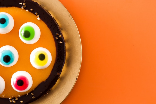 Tort Halloween z ozdobą oczu cukierków na pomarańczowo.
