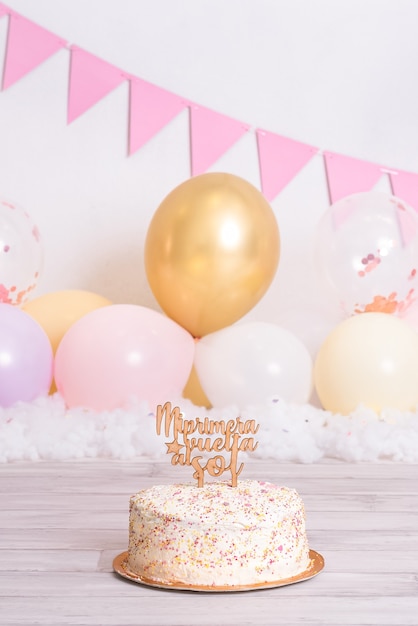 Zdjęcie tort urodzinowy z kolorowymi kulkami. na szczycie, gdzie jest napisane „mój pierwszy powrót na słońce”. świętowanie urodzin. pierwszy rok dziecka.