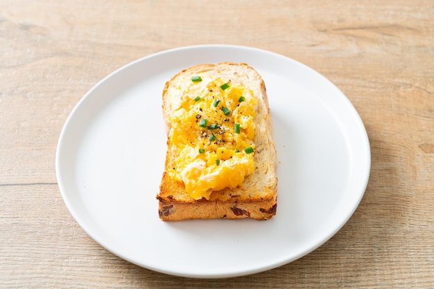 tost chlebowy z jajecznicą na białym talerzu