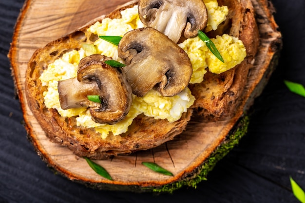 Tost pełnoziarnisty z jajecznicą z pieczarkami i twarogiem. zdrowe śniadanie lub brunch.