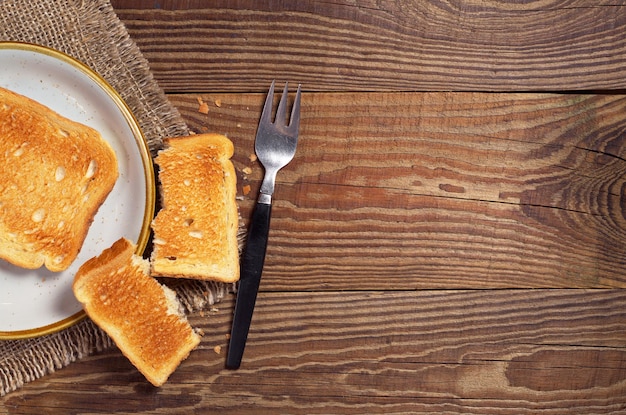 Tostowy chleb i widelec na starym drewnianym stole widok z góry Miejsce na tekst