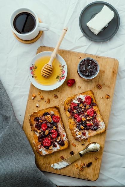 Zdjęcie tosty z miodem, serem śmietankowym, konfiturą z czerwonych owoców i kawą