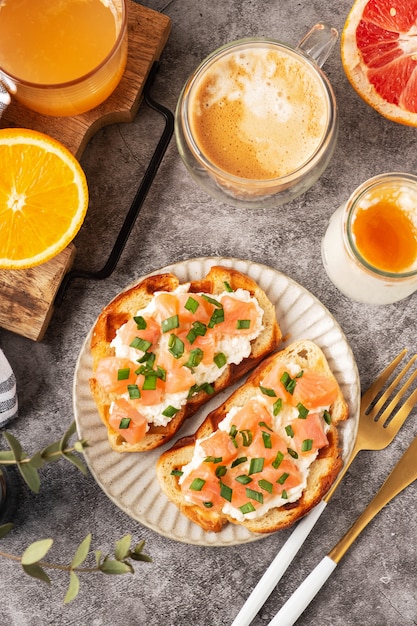 Tosty z serem i łososiem, koncepcja śniadania z kawą i świeżo wyciśniętym sokiem pomarańczowym, zdrowe jedzenie.