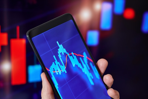 Trader analizuje dane giełdowe w smartfonie