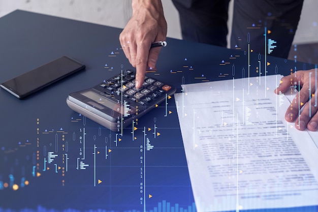 Trader obliczający dane historyczne w celu przewidywania zachowania giełdy Koncepcja handlu internetowego Forex i finansowy wykres hologramowy nad biurkiem i kalkulatorem