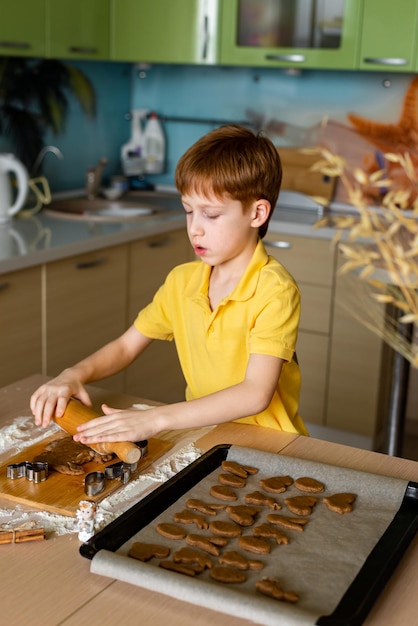 Tradycje wielkanocne Koncept żywieniowy Przygotowanie do wielkanocnego pieczenia Portret rudowłosego chłopca, który robi ciasto do pieczenia ciasteczek