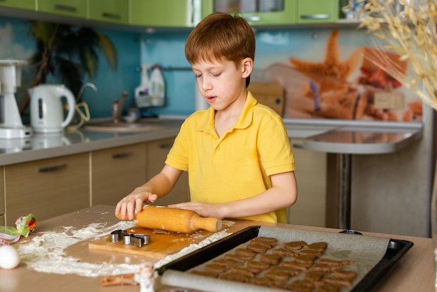 Tradycje wielkanocne Koncept żywieniowy Przygotowanie do wielkanocnego pieczenia Portret rudowłosego chłopca, który robi ciasto do pieczenia ciasteczek