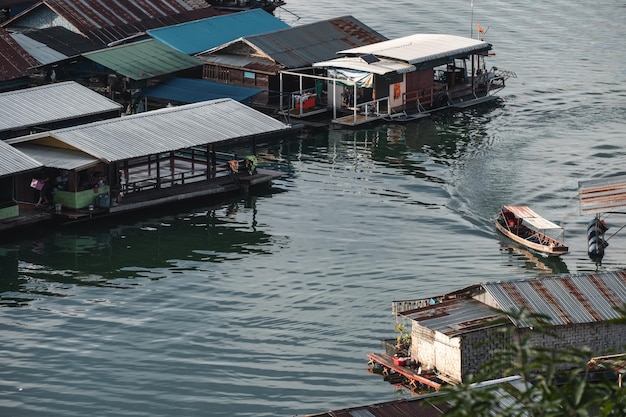 Tradycyjna drewniana tratwa pływająca z łodzią typu longtail na rzece w Sangkhlaburi Thailand