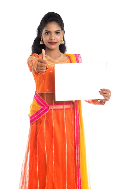 Tradycyjna kobieta trzyma i pokazuje pusty biały szyld lub tablicę na białym tle.