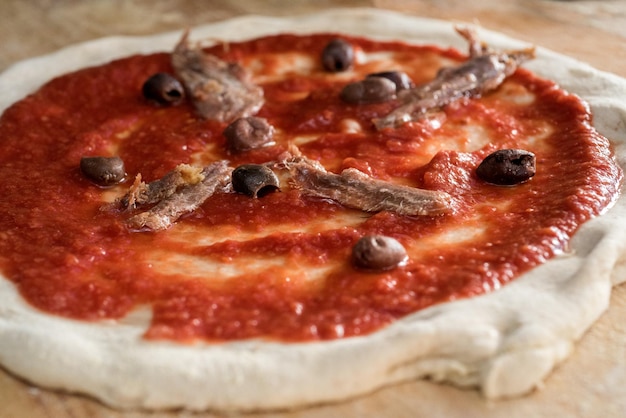 Tradycyjna pizza neapolitańska z sosem pomidorowym, anchoisami, czarnymi oliwkami, procesem fermentacji