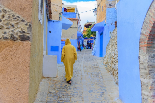 Tradycyjna Scena Z Ludźmi Przechodzącymi Przez Ulicę Z Niebieskimi Fasadami Wioski Chefchaouen