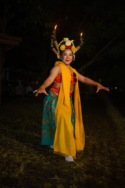 Tradycyjna Tancerka Jawańska Tańczy Z Kolorowymi Kwiatami Na Pięści Na Scenie W Nocy