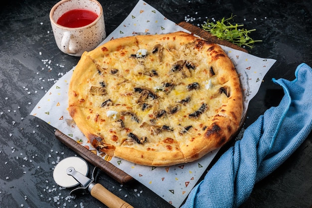 Tradycyjna włoska pizza z salami, serem, pomidorami, grzybami, zielenią Widok z góry na ciemny kamień t