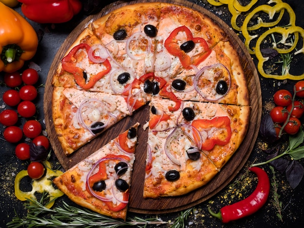 Tradycyjne dania kuchni włoskiej. pyszny kawałek pizzy cebula pieprz oliwki