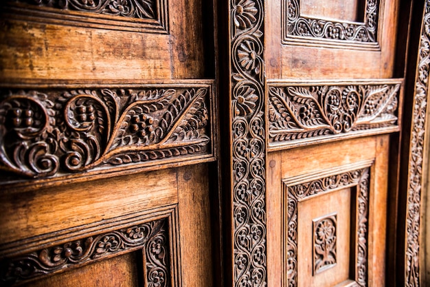 Tradycyjne drewniane drzwi zanzibarskie z artystyczną rzeźbą i typowym zanzibarskim wzornictwem.