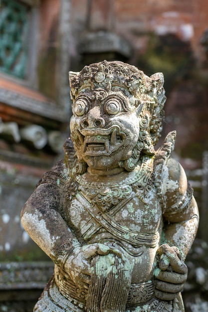 Tradycyjne kamienne posągi przedstawiające demona, boga i balijskich bóstw mitologicznych w Ubud, wyspa Bali, Indonezja, z bliska. Ręka kamienna statua ze znakiem fig