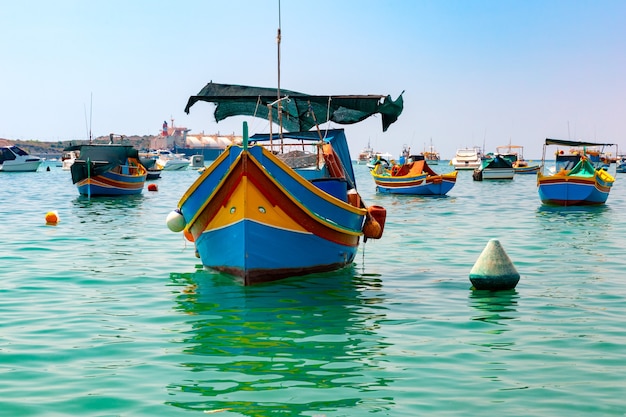 Tradycyjne kolorowe łodzie Luzzu w porcie w śródziemnomorskiej wiosce rybackiej Marsaxlokk, Malta