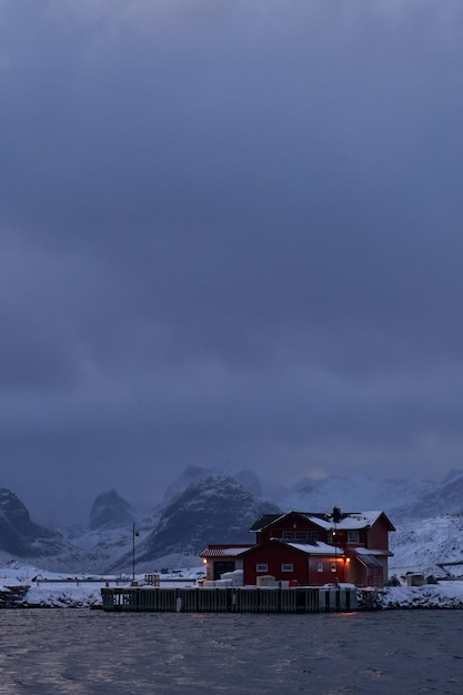 Tradycyjne norweskie chaty i łodzie rybackie na wyspie Lofoty w północnej Norwegii. Zła pogoda w sezonie zimowym