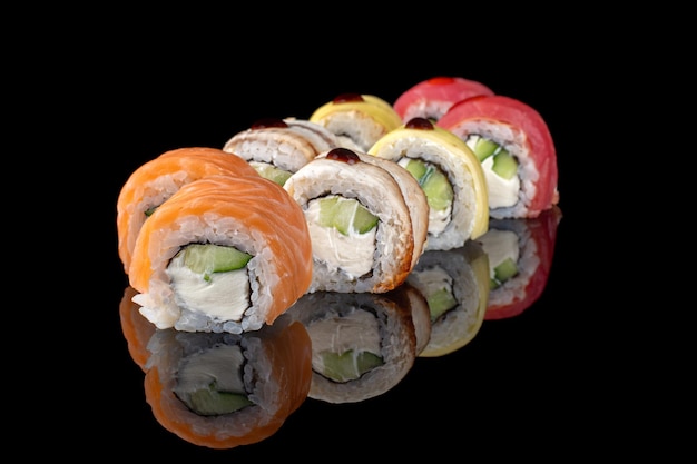 Tradycyjne pyszne świeże rolki sushi ustawione na czarnym tle z odbiciem Sushi menu Japońska kuchnia restauracja